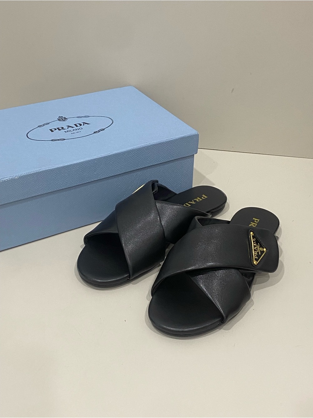 Prada Black Crisscross Leather Mules with Gold Logo